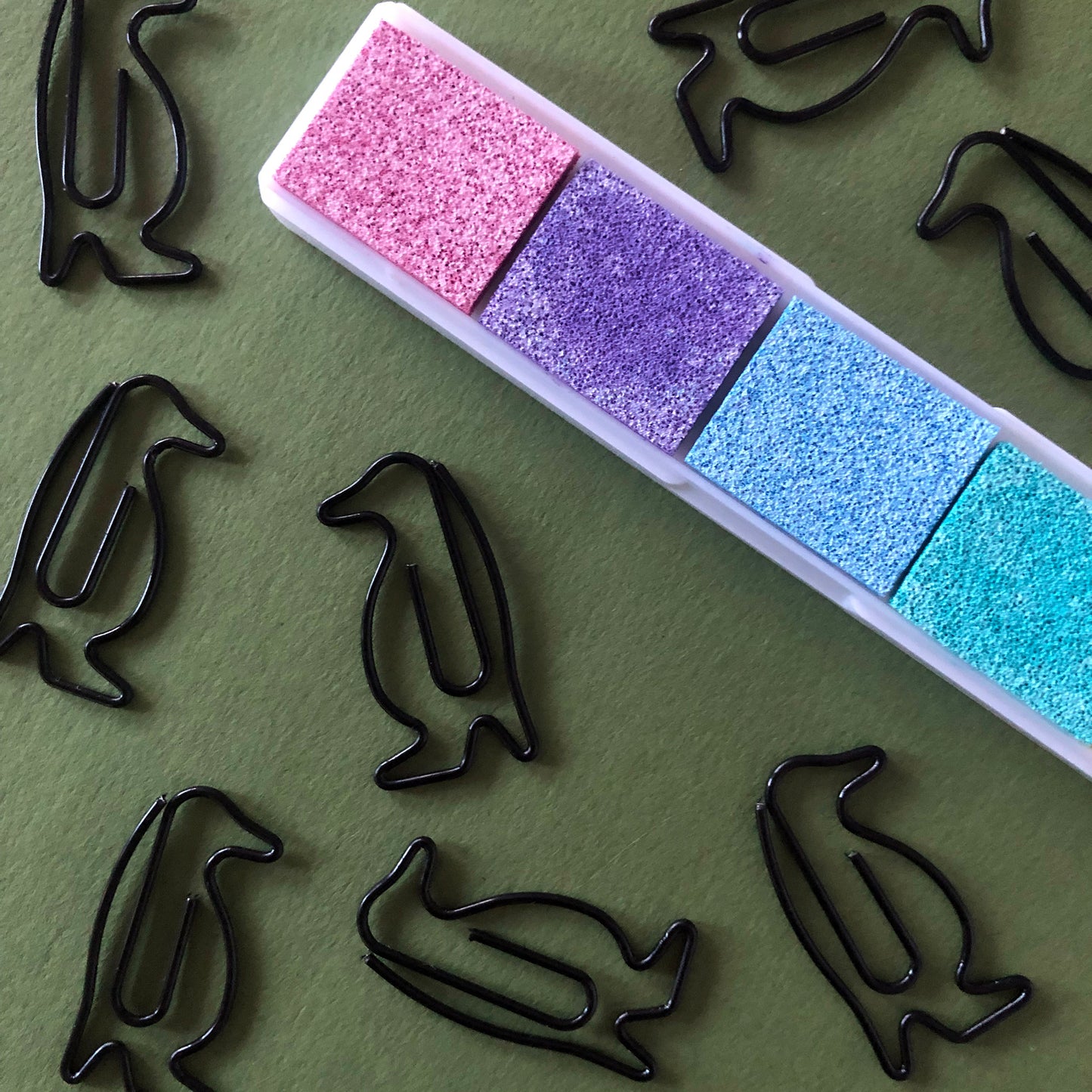 Image shows a set of black penguin shaped paperclips.
