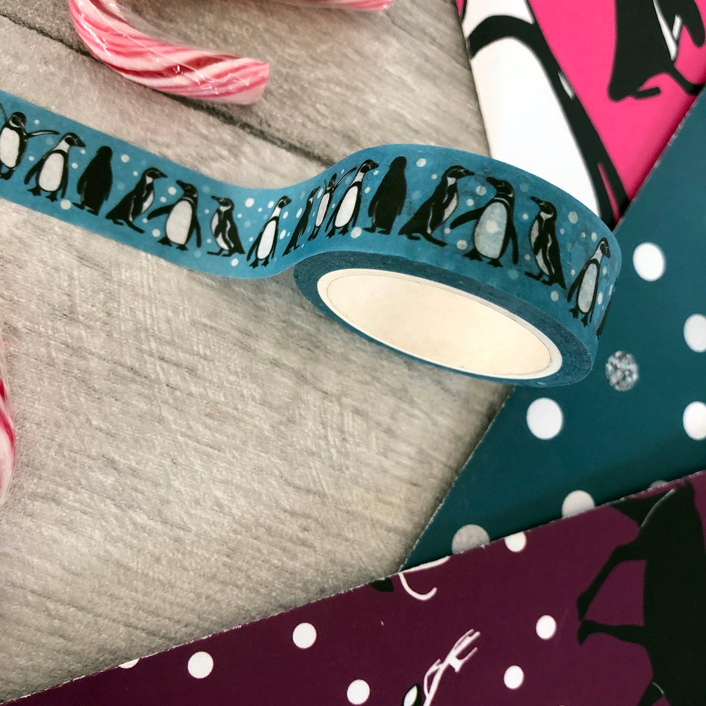Image shows a blue washi tape with a fun penguin and snowball print