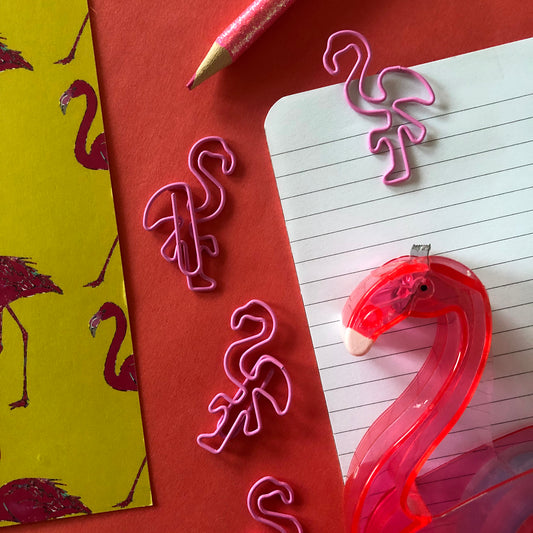 Image shows a set of pink flamingo shaped paperclips.