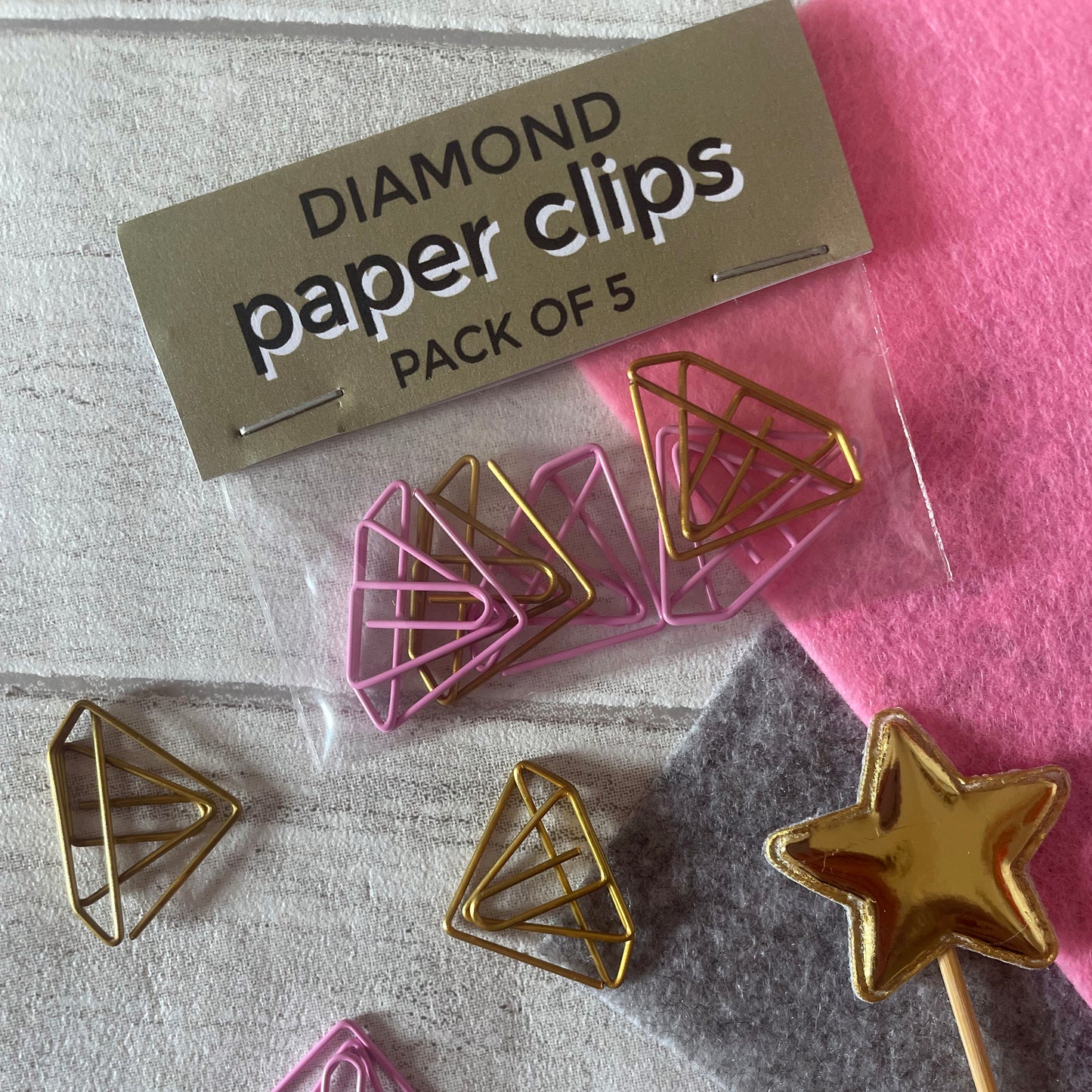 Image shows a set of pink and gold, diamond shaped paperclips.