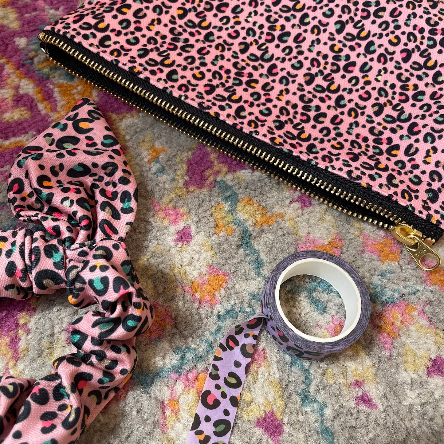 Image shows a useful zip pouch in a pretty pink colour with a leopard print pattern with pops of neon.