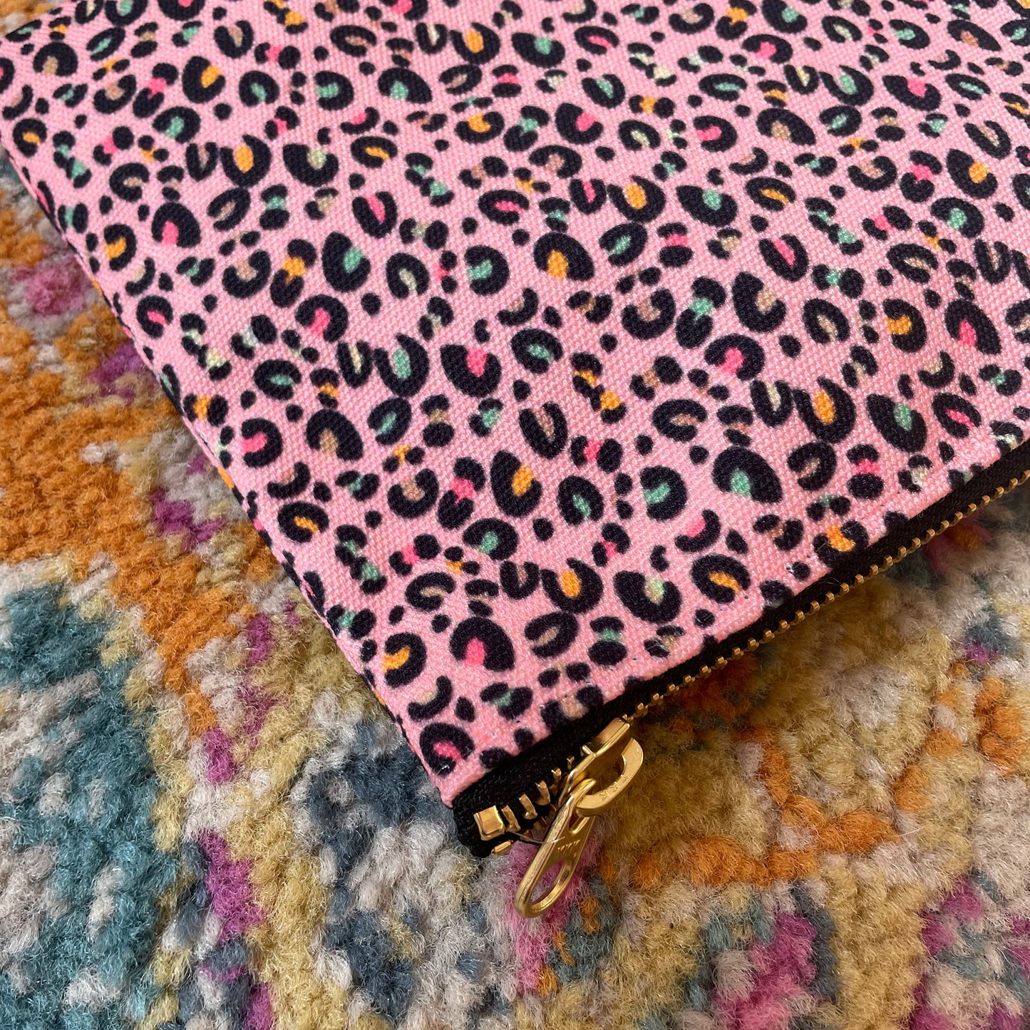 Image shows a useful zip pouch in a pretty pink colour with a leopard print pattern with pops of neon.