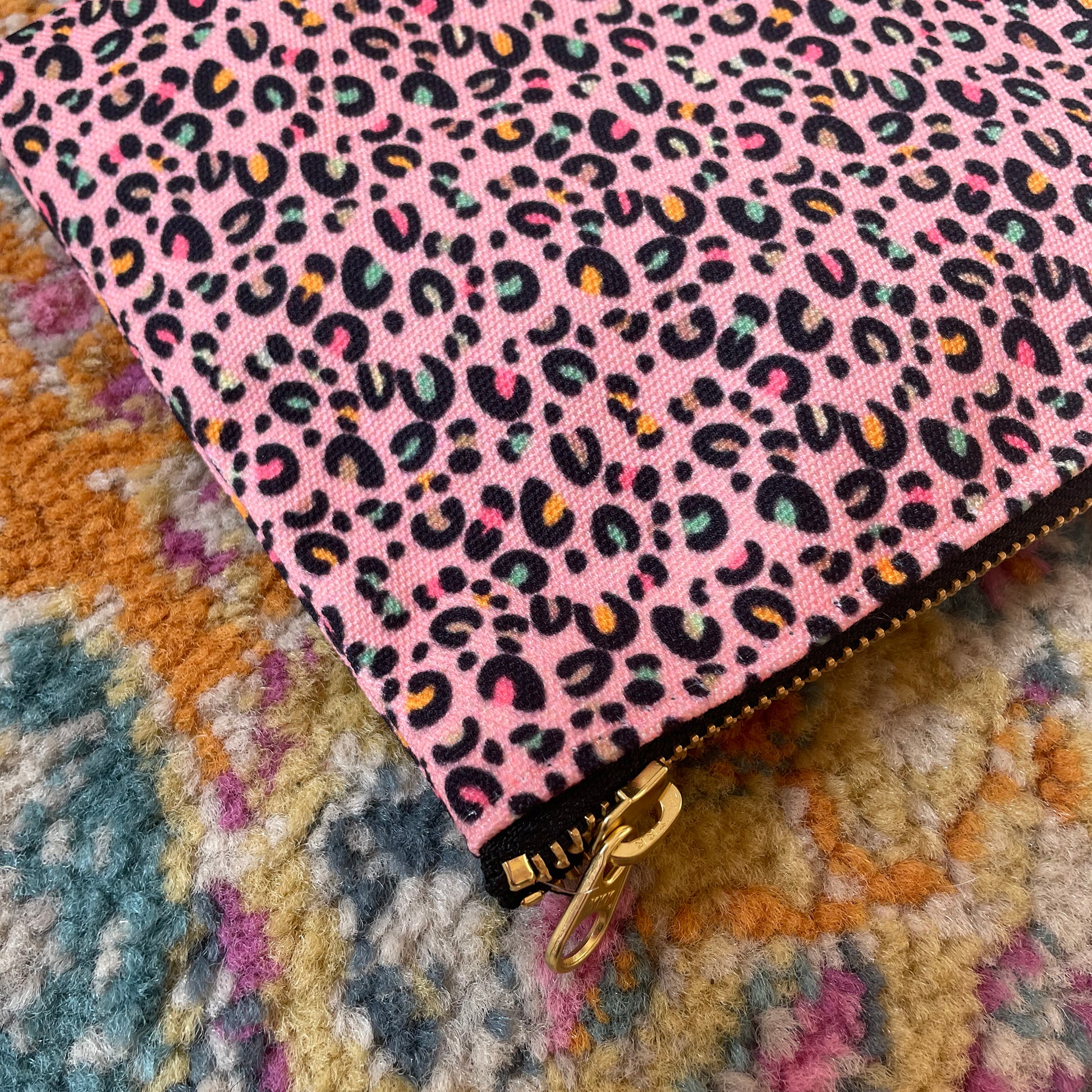 Image shows a useful zip pouch in a pretty pink colour with a leopard print pattern with pops of neon.