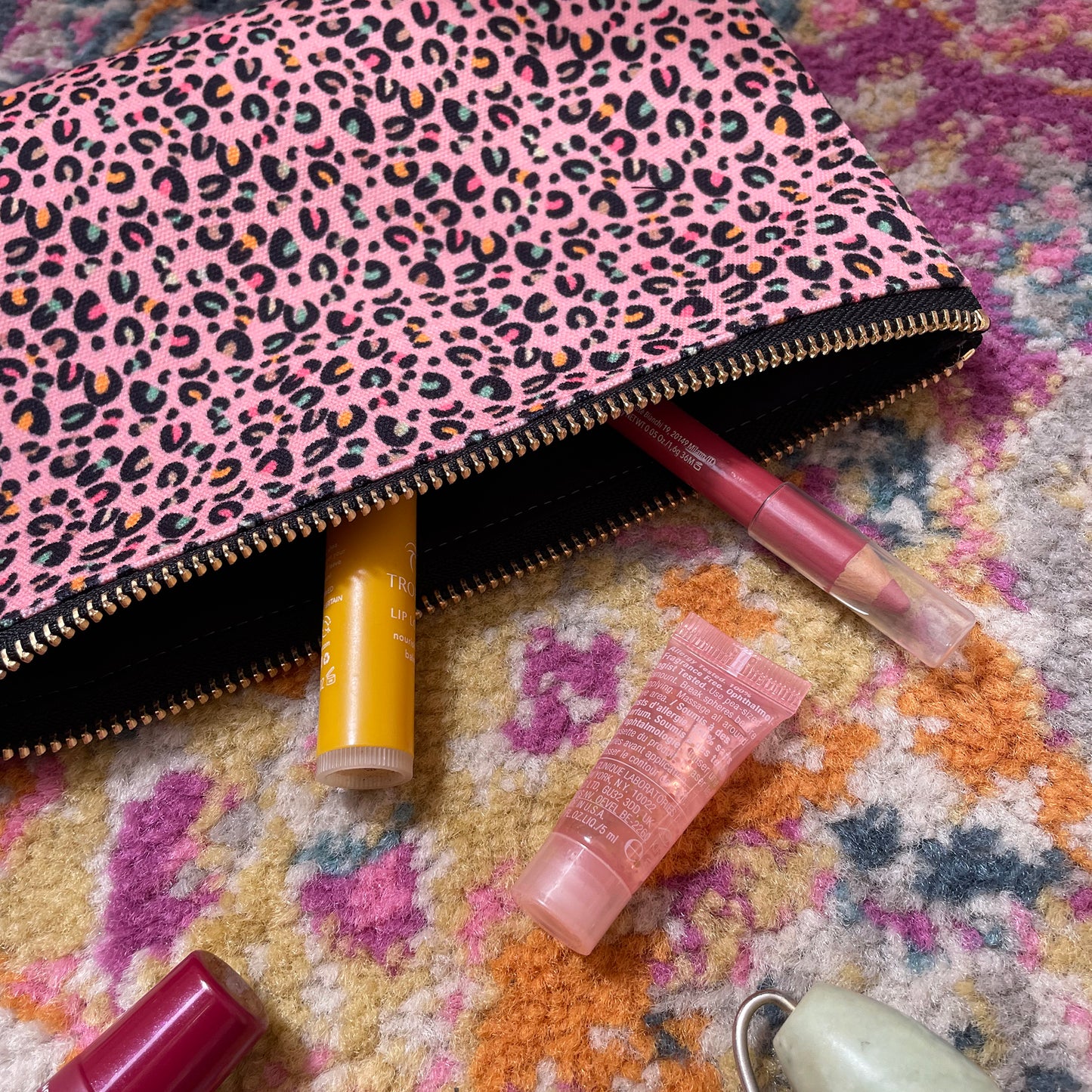 Image shows a useful zip pouch in a pretty pink colour with a leopard print pattern with pops of neon.