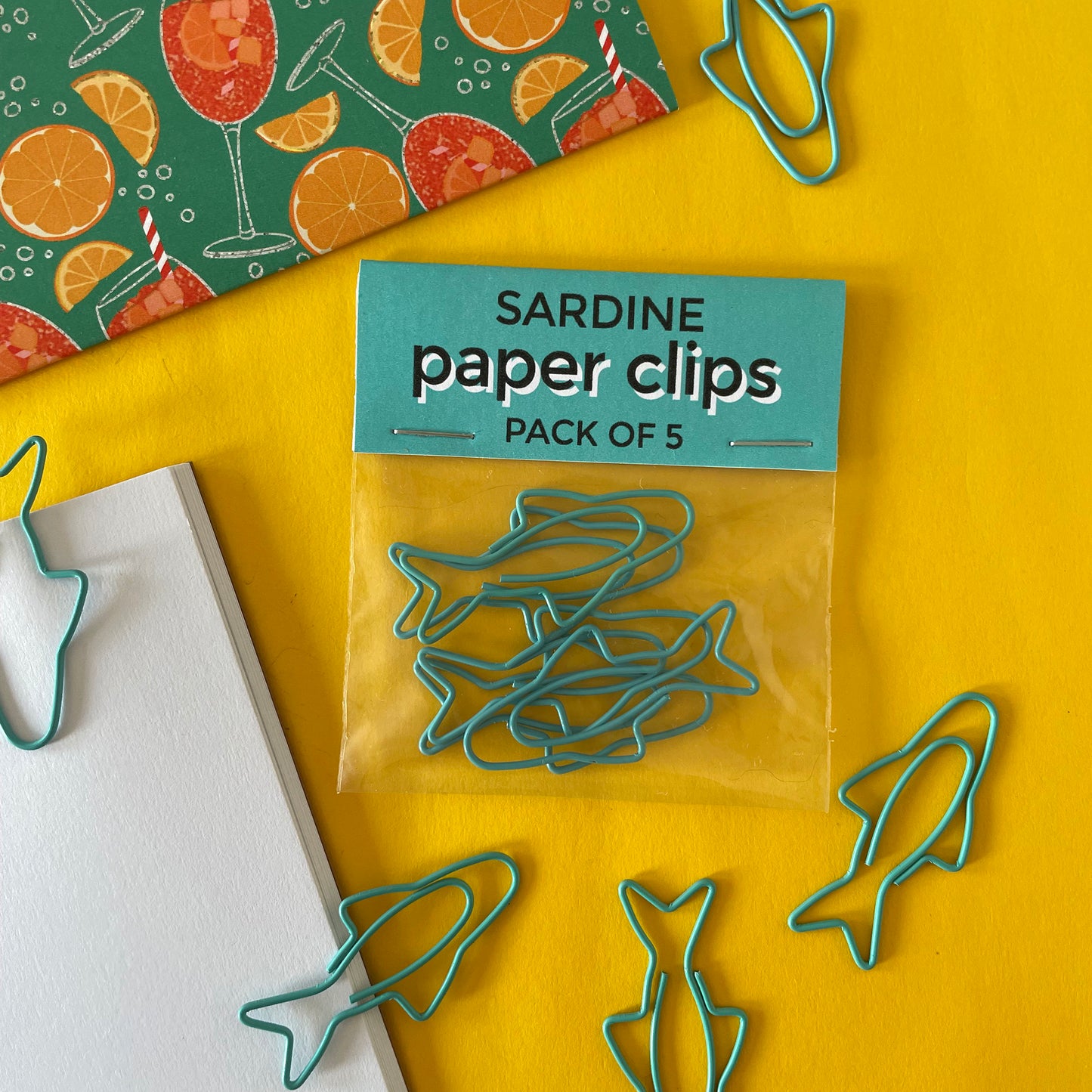 Image shows a fun set of 5 turquoise paper clips shaped like sardines