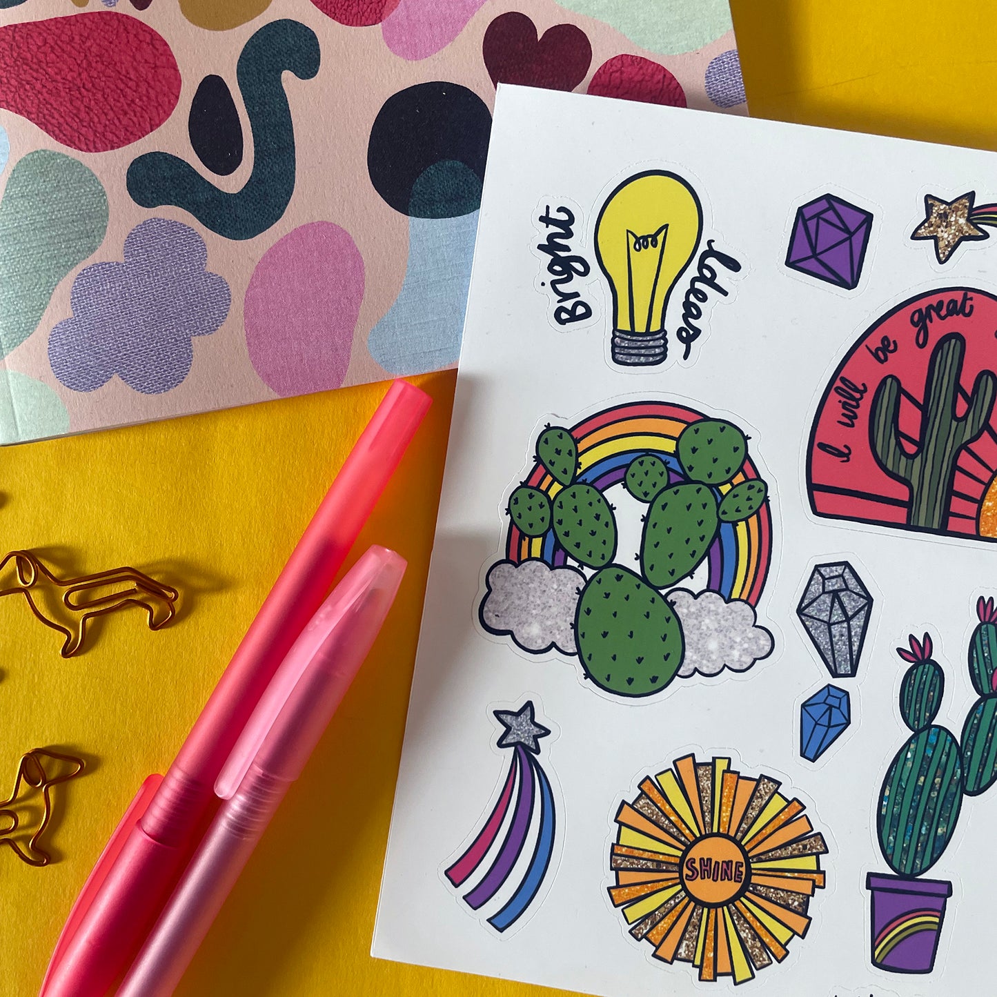 Image shows a bright and colourful sticker sheet with illustrated designs of cacti, gems and other bright designs.