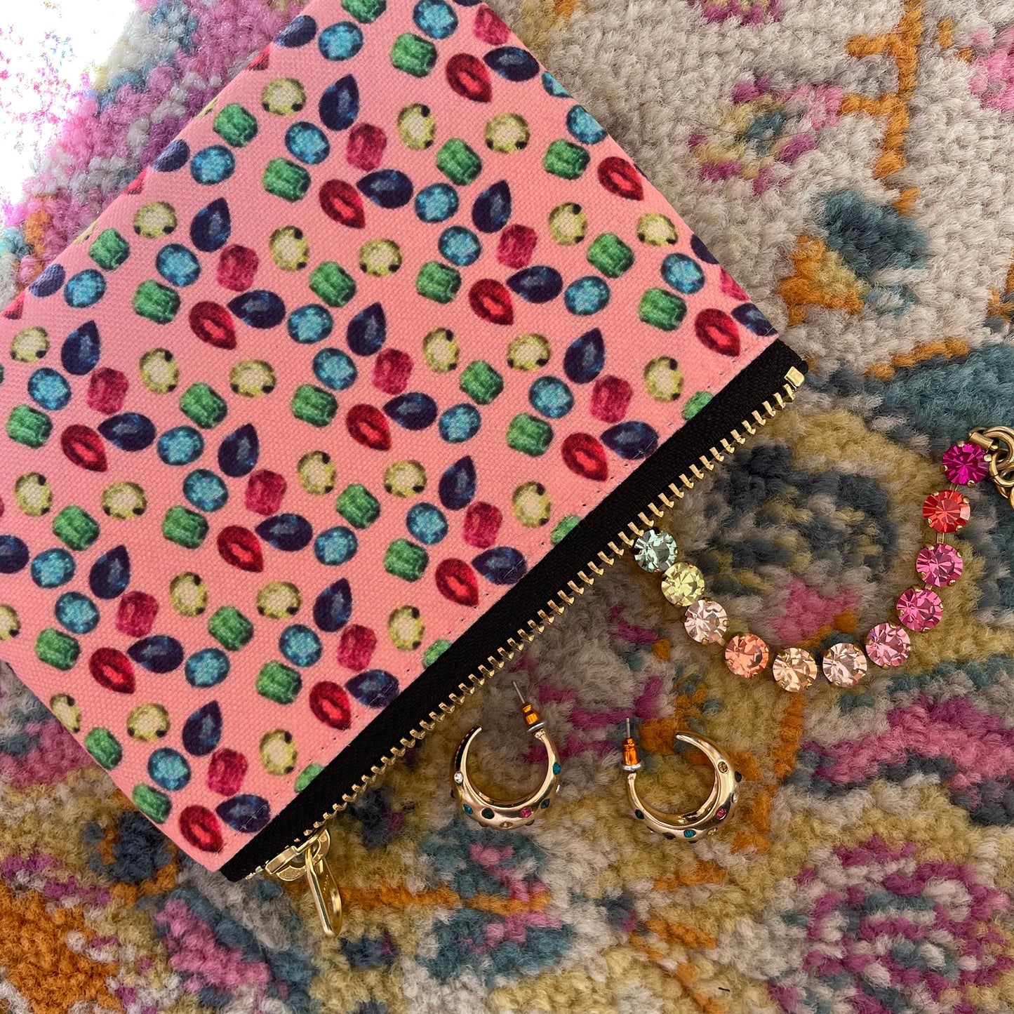 Image shows a handy zip pouch in pastel pink featuring a unique colourful gemstone pattern