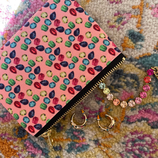 Image shows a handy zip pouch in pastel pink featuring a unique colourful gemstone pattern