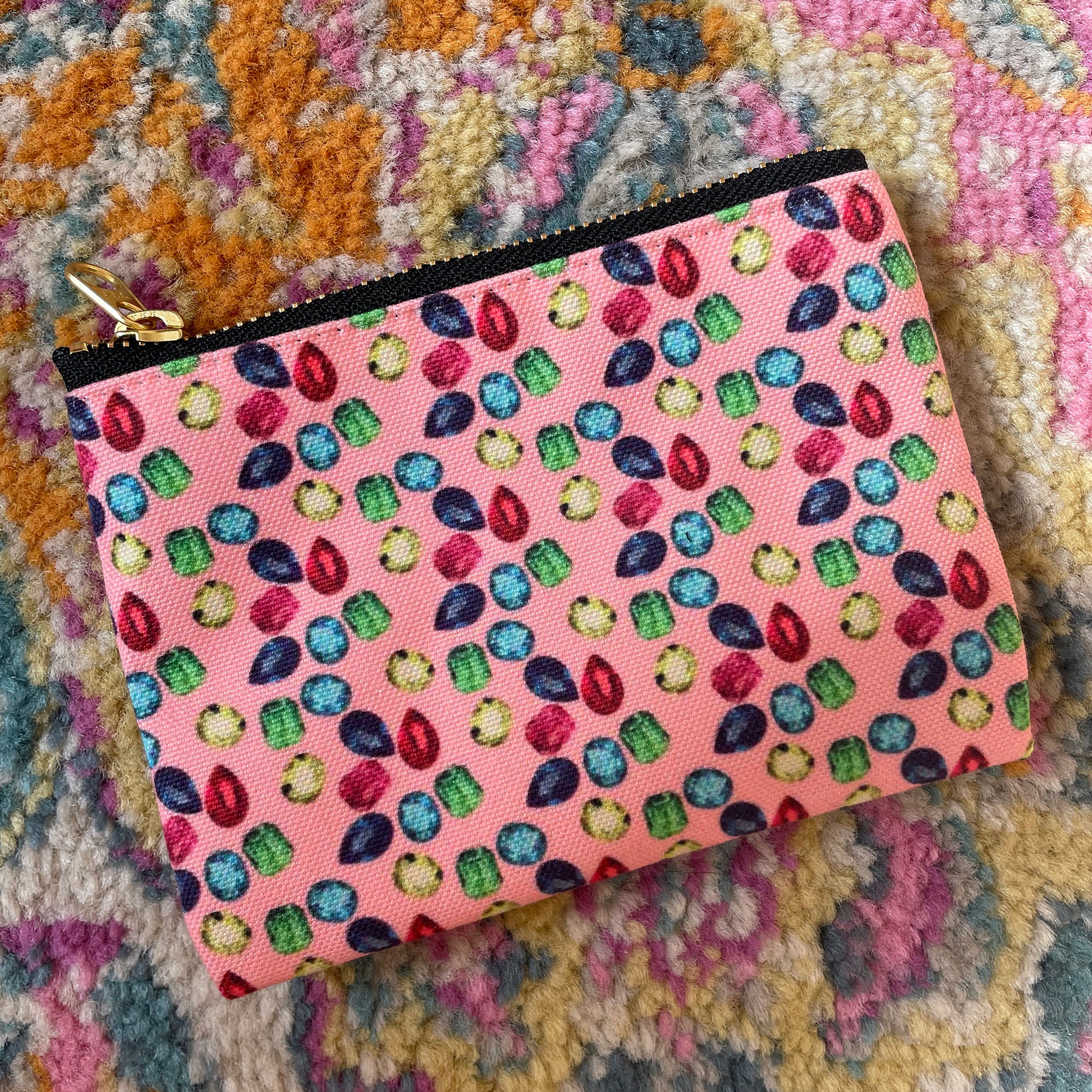 Image shows a handy zip pouch in pastel pink featuring a unique colourful gemstone pattern
