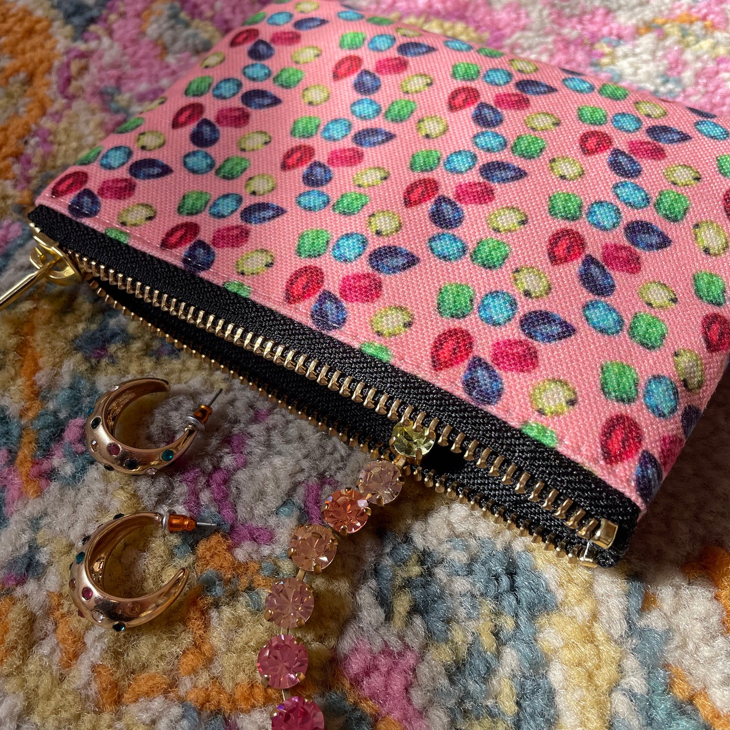 Image shows a handy zip pouch in pastel pink featuring a unique colourful gemstone pattern