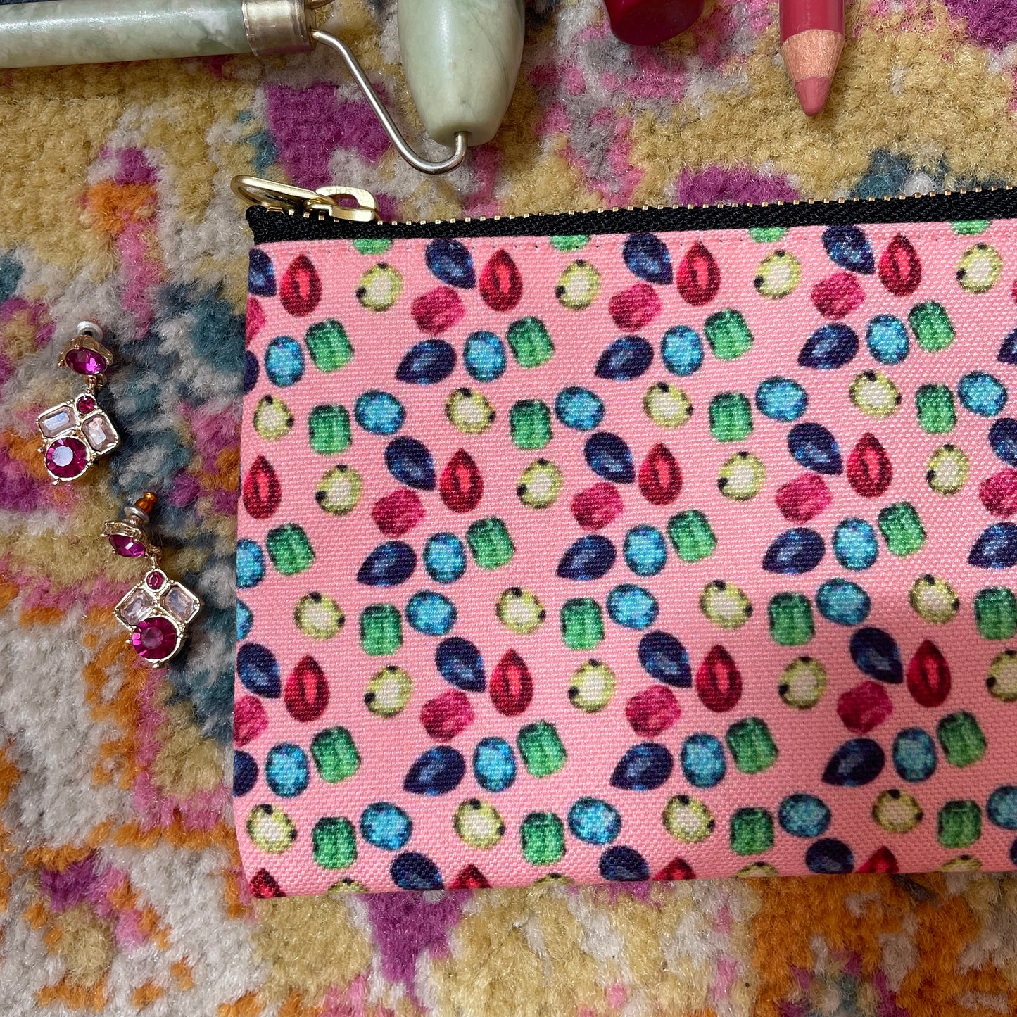 Image shows a handy zip pouch in pastel pink featuring a unique colourful gemstone pattern