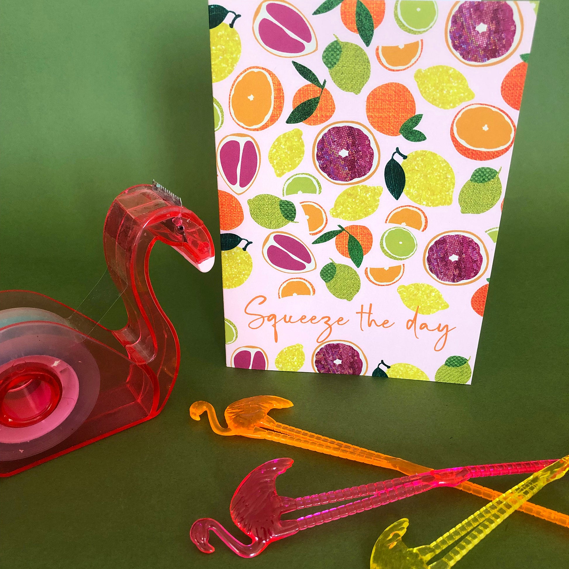 Image shows an everyday greetings card that says 'squeeze the day' and features a fun pattern of lemons, oranges, tangerines and grapefruit