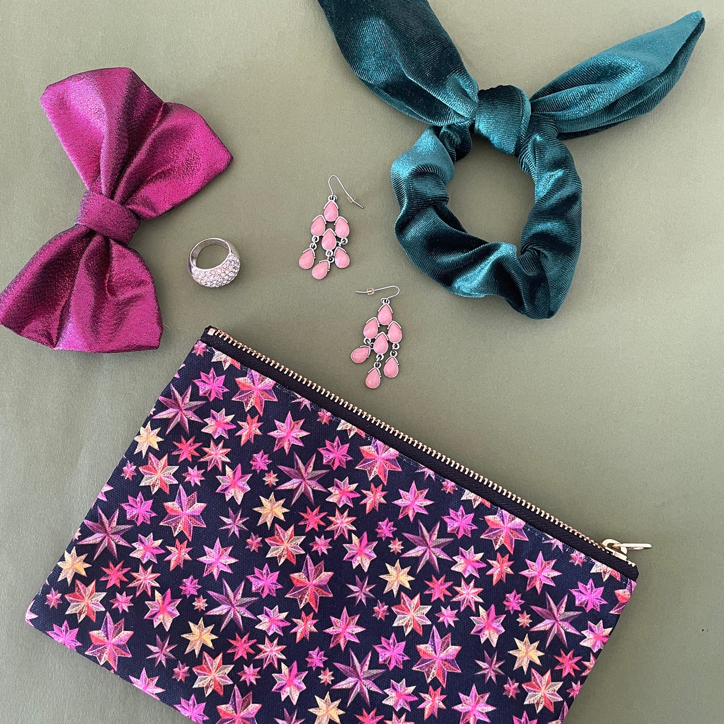 Image shows a black zip pouch with a bright pink, orange and gold starlight lantern design.
