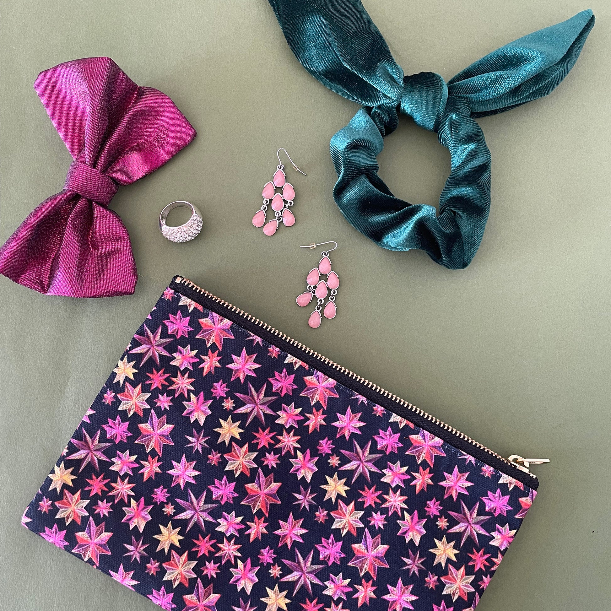 Image shows a black zip pouch with a bright pink, orange and gold starlight lantern design.