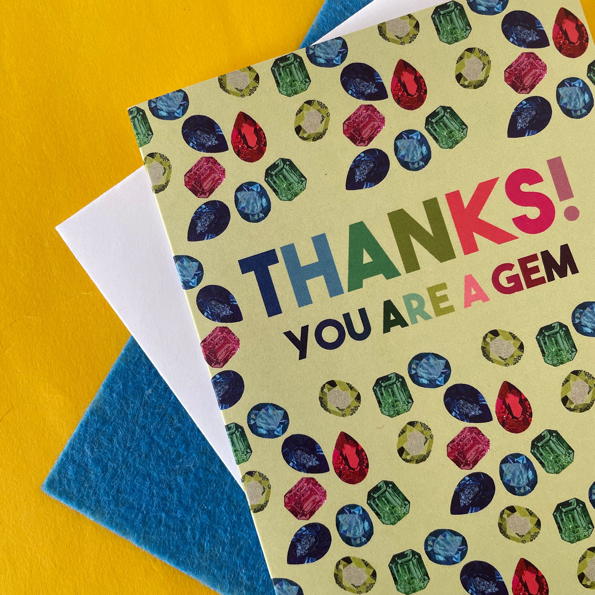 Image shows a light green greetings card with illustrations of gemstones and the words 'thanks you are a gem"