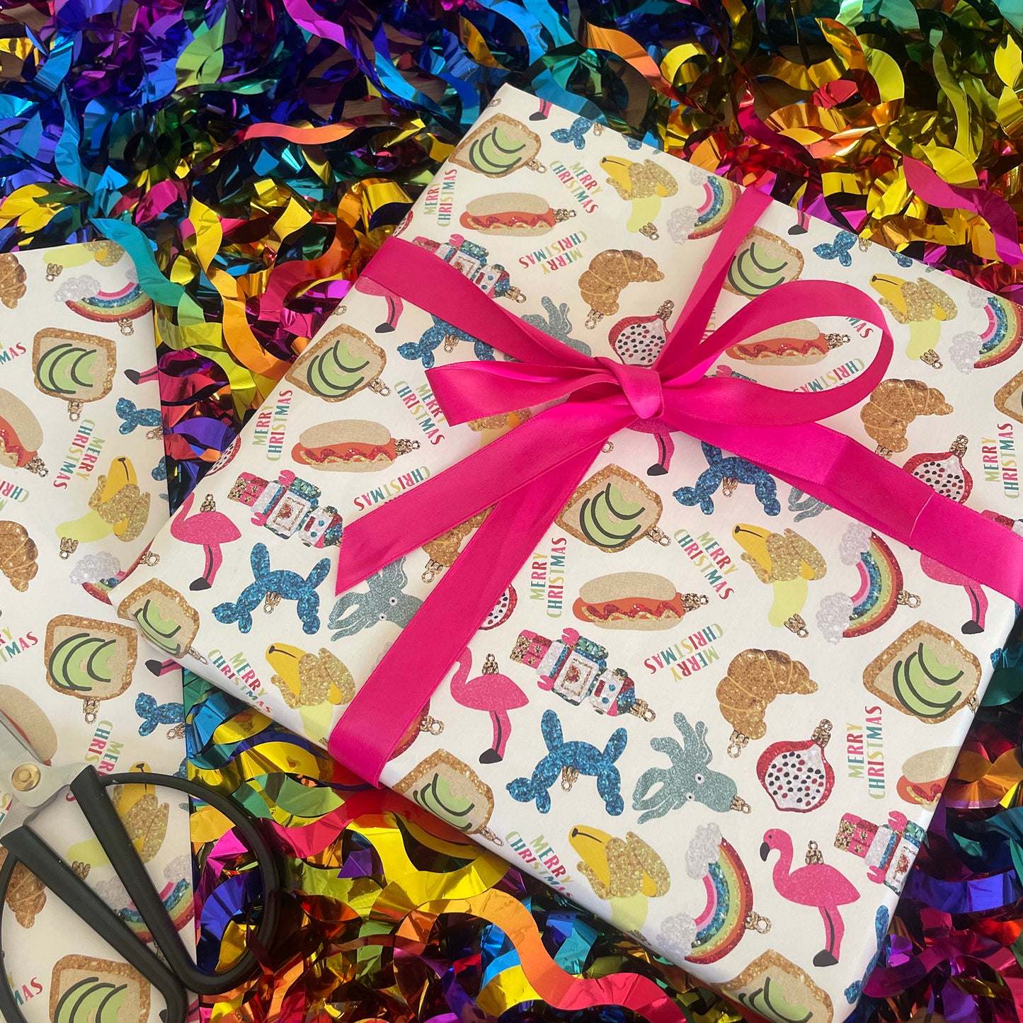 Image shows a wrapped gift fun trinkets gift wrap. The design features a quirky bauble pattern.