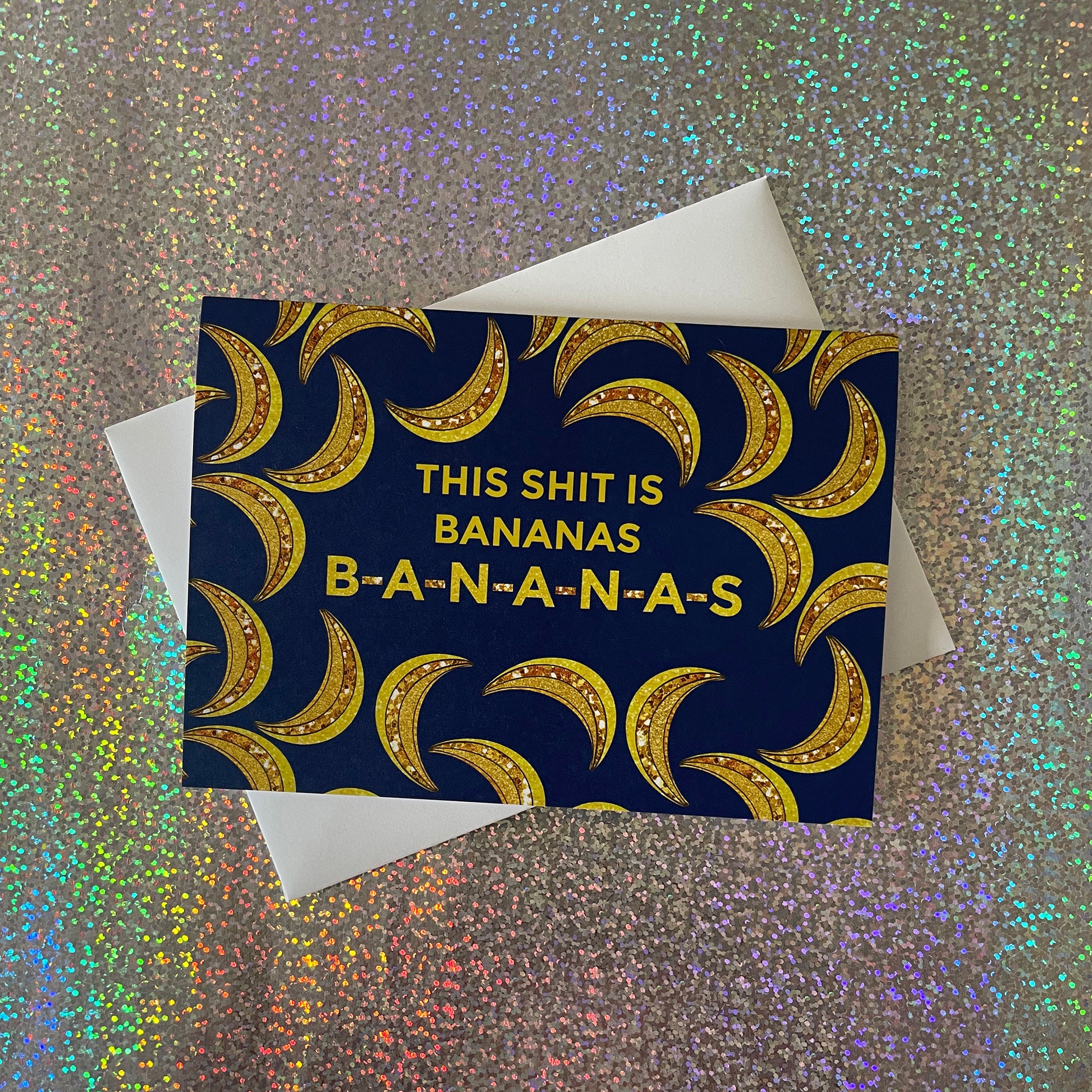 Image of a blue card featuring bejewelled illustrations of bananas and the message 'This Shit is Bananas B-A-N-A-N-A-S.