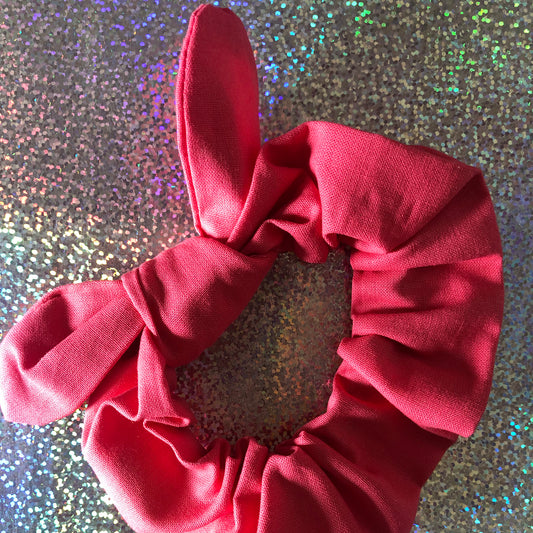 Image shows a coral cotton hair scrunchie with a knot and bow
