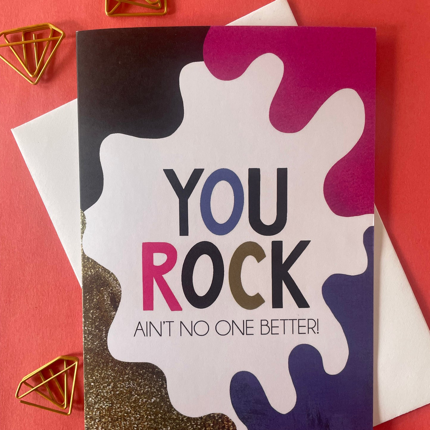 Image shows a bright greetings card with colourful, abstract shapes around the edge and the wording "You Rock ain't no one better"