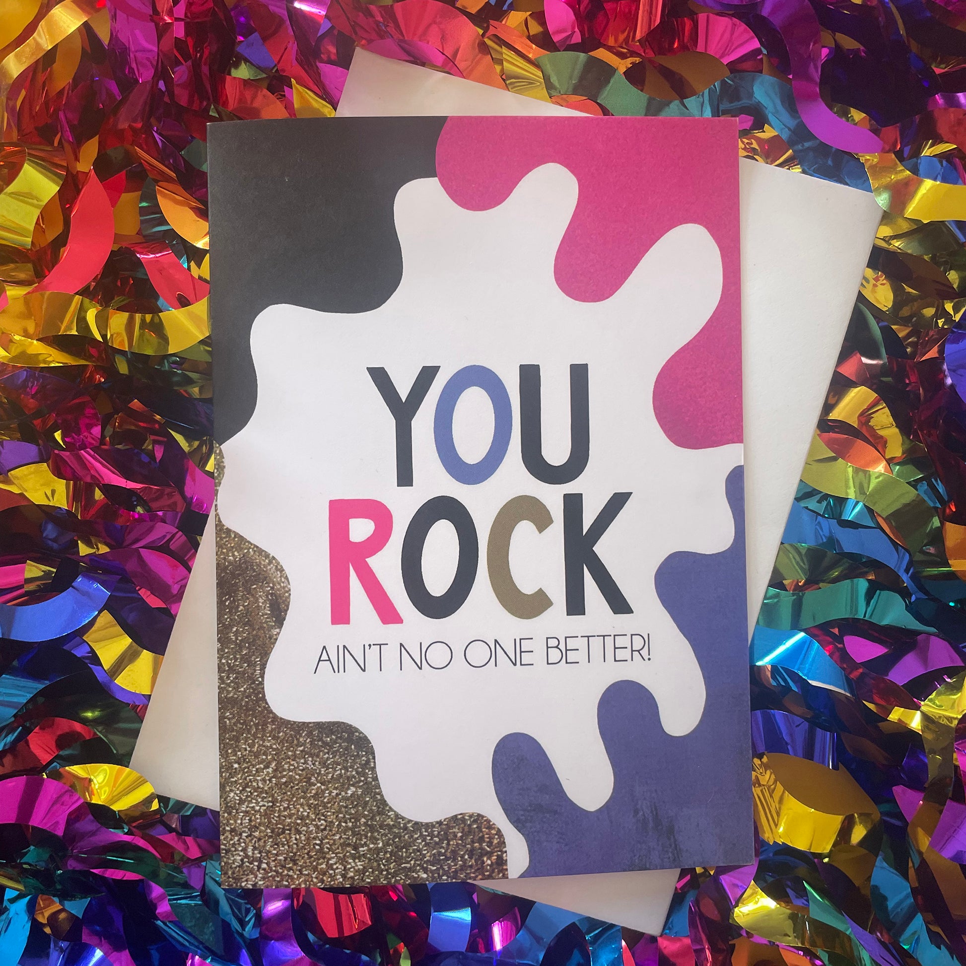 Image shows a bright greetings card with colourful, abstract shapes around the edge and the wording "You Rock ain't no one better"