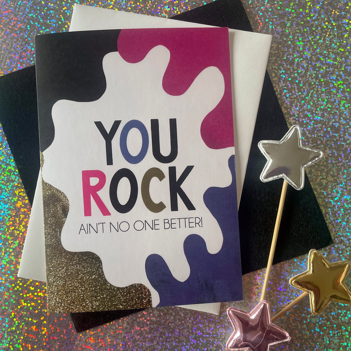 Image shows a bright greetings card with colourful, abstract shapes around the edge and the wording "You Rock ain't no one better"