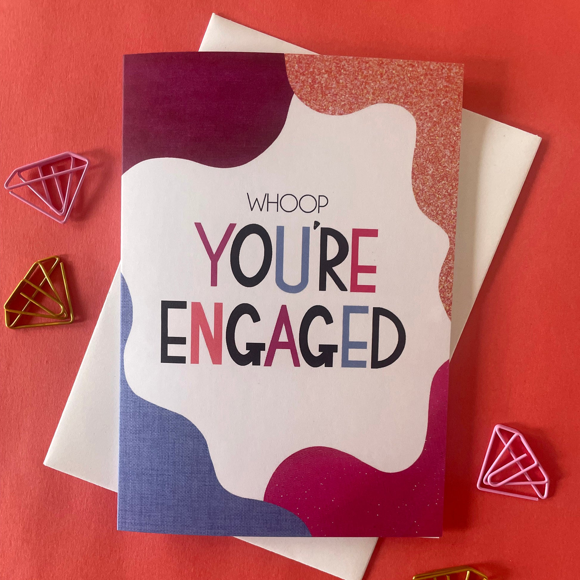 Image shows a bright greetings card with colourful, abstract shapes around the edge and the wording "Whoop you're engaged""