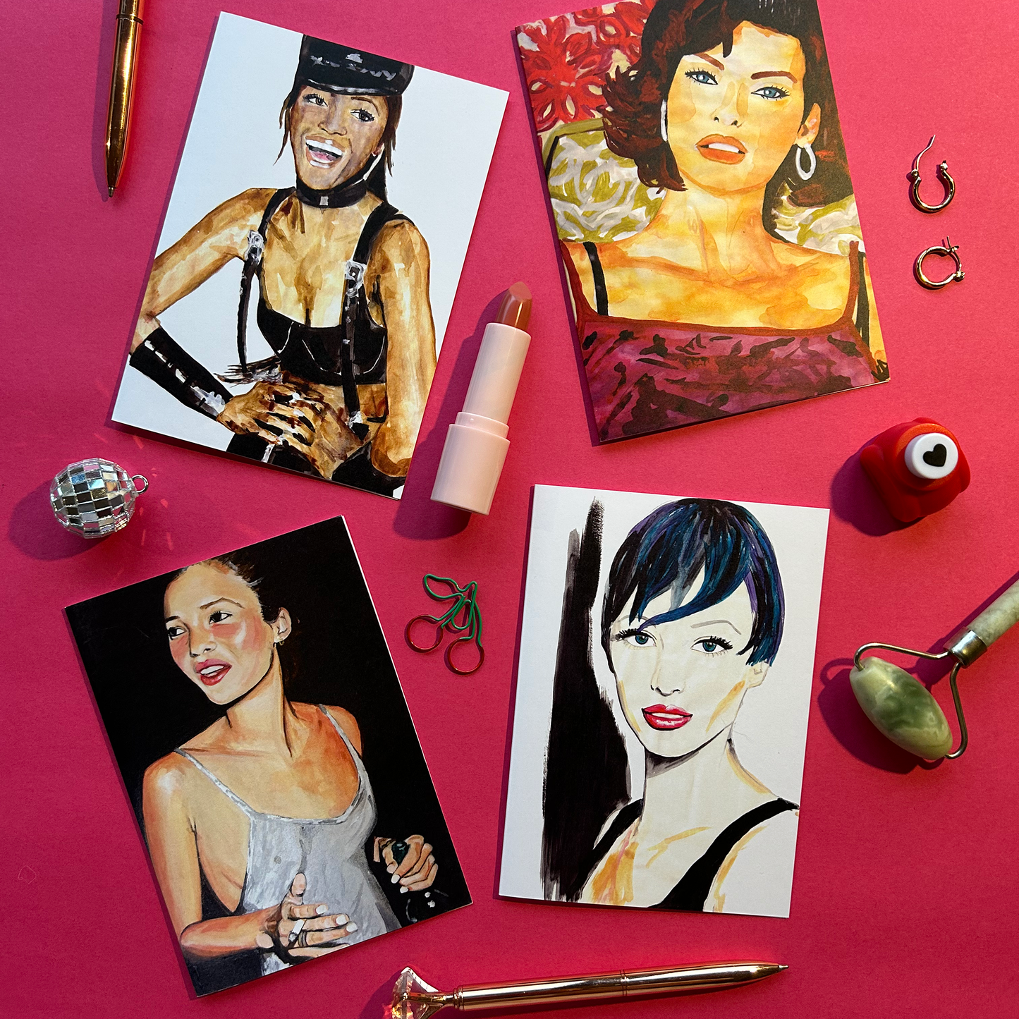 Four artistic portraits of women on postcards with makeup items on a pink background