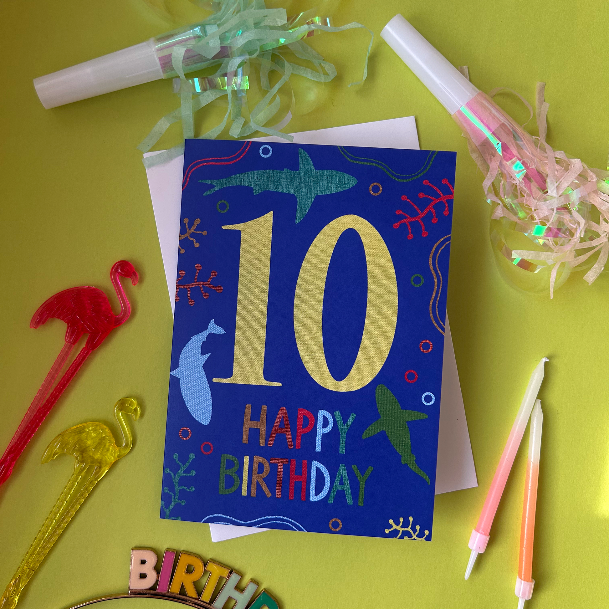 Birthday card with number 10 on a yellow background with party supplies