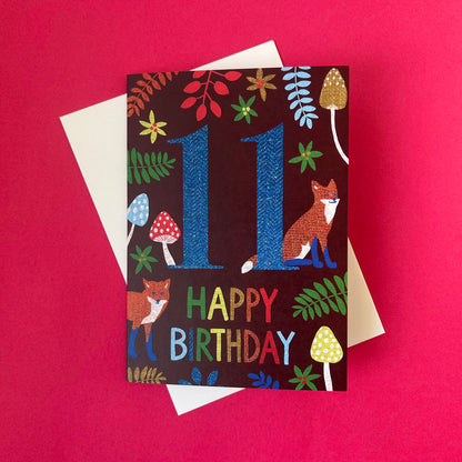 Birthday card with number 11 and fox illustration on a red background