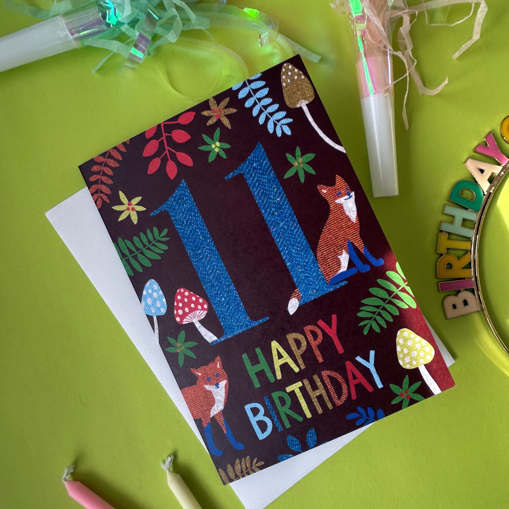 Birthday card with foxes and colourful text on a green background