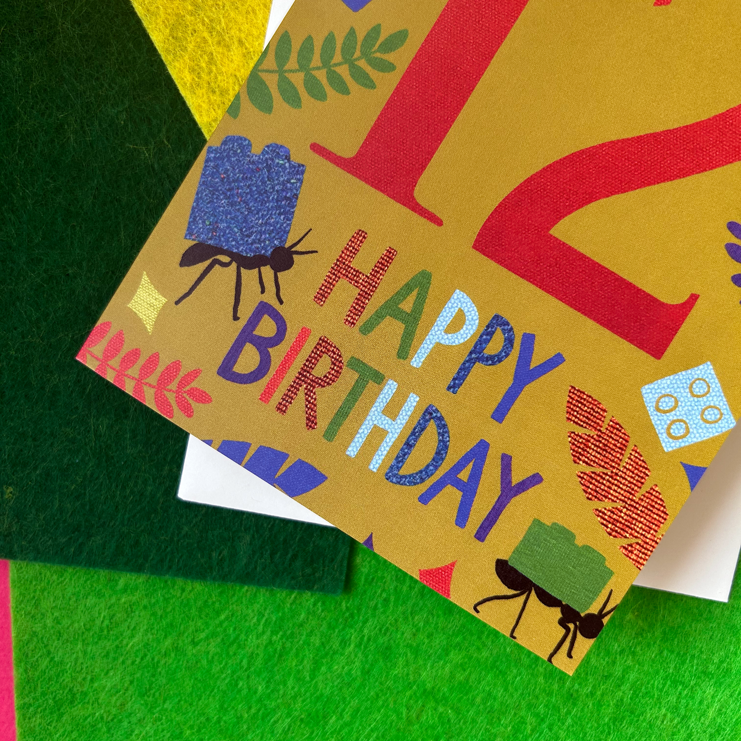 Colourful birthday card with ants and colorful text on a green background