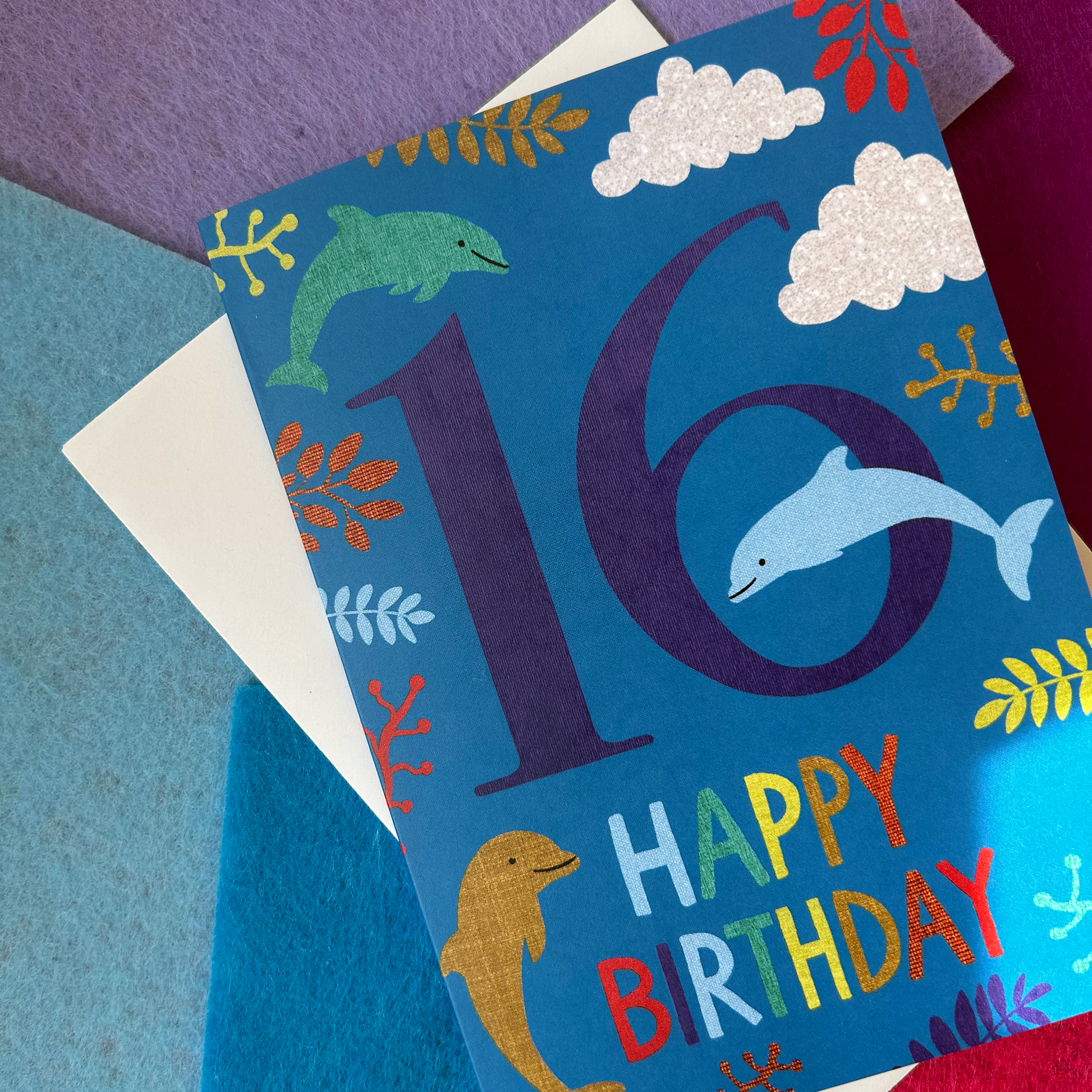 Birthday card with number 16 and dolphins on a blue background