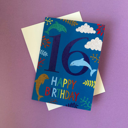 Birthday card with dolphins and number 16 on a purple background