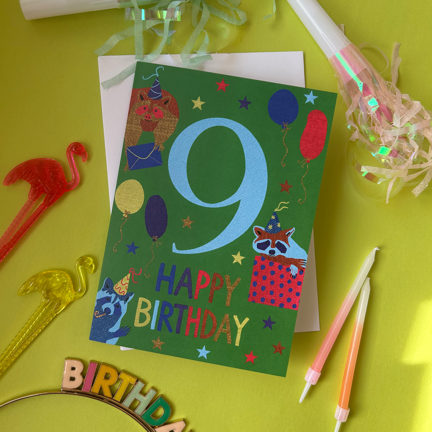 Colorful birthday card with number 9 on a yellow background with party supplies.