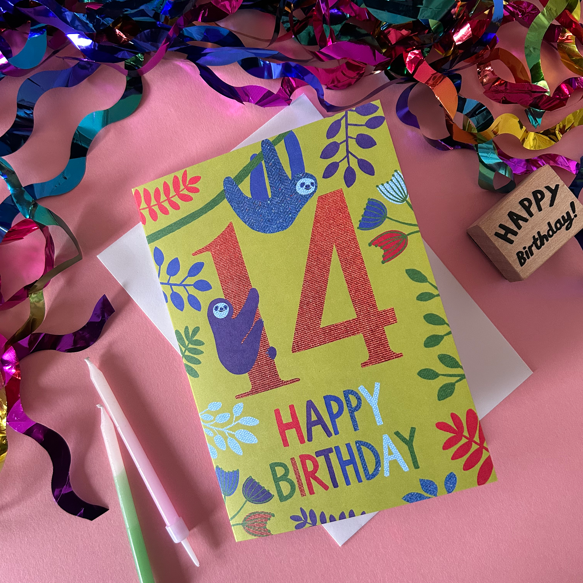 Birthday card with sloth design and 'Happy Birthday' text on a pink background with colorful streamers.