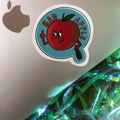 Image shows a vinyl sticker featuring an illustration of a red apple swearing and drinking with the wording 'Bad Apple'