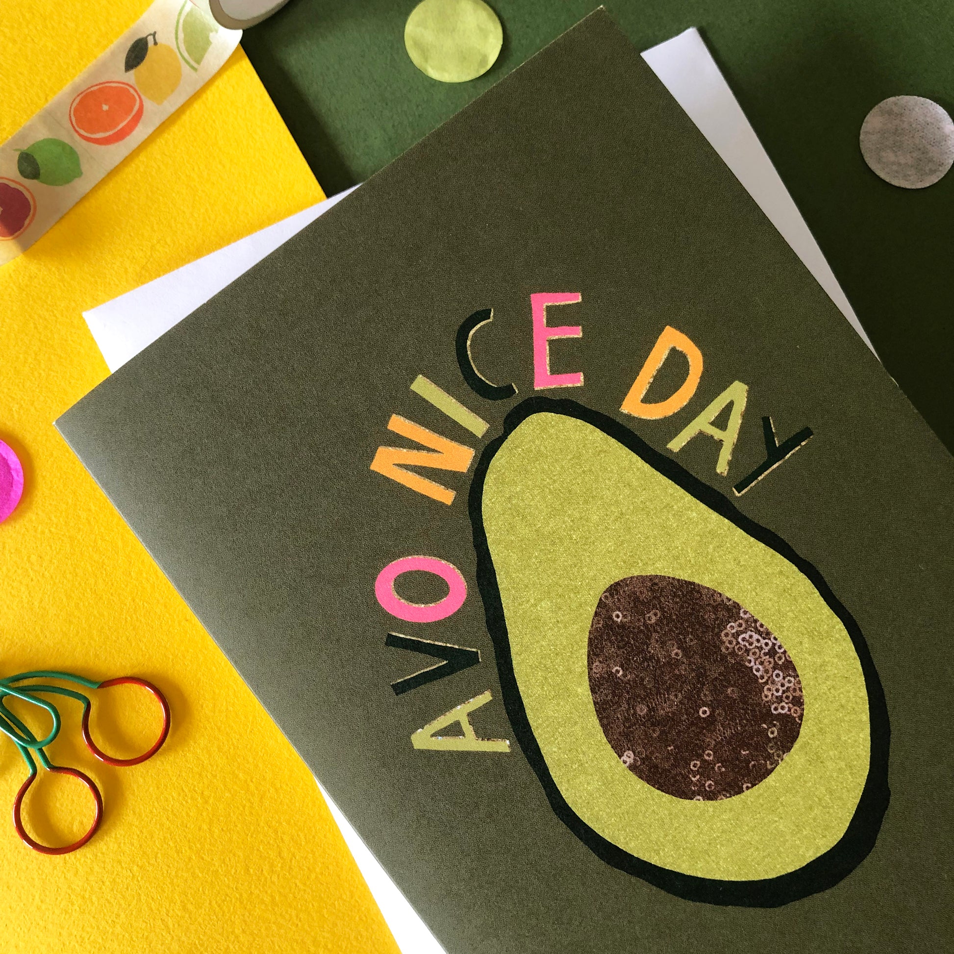 Image shows a green "everyday" greetings card that says 'avo nice day' and features an illustration of an avocado