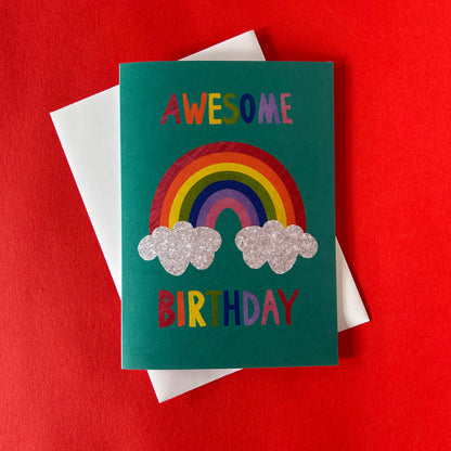 Birthday card with rainbow and clouds on a red background