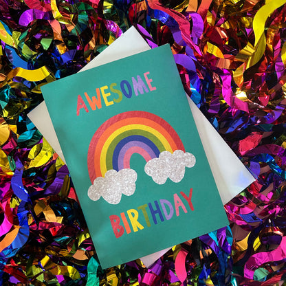 Birthday card with rainbow and clouds on a colourful confetti background