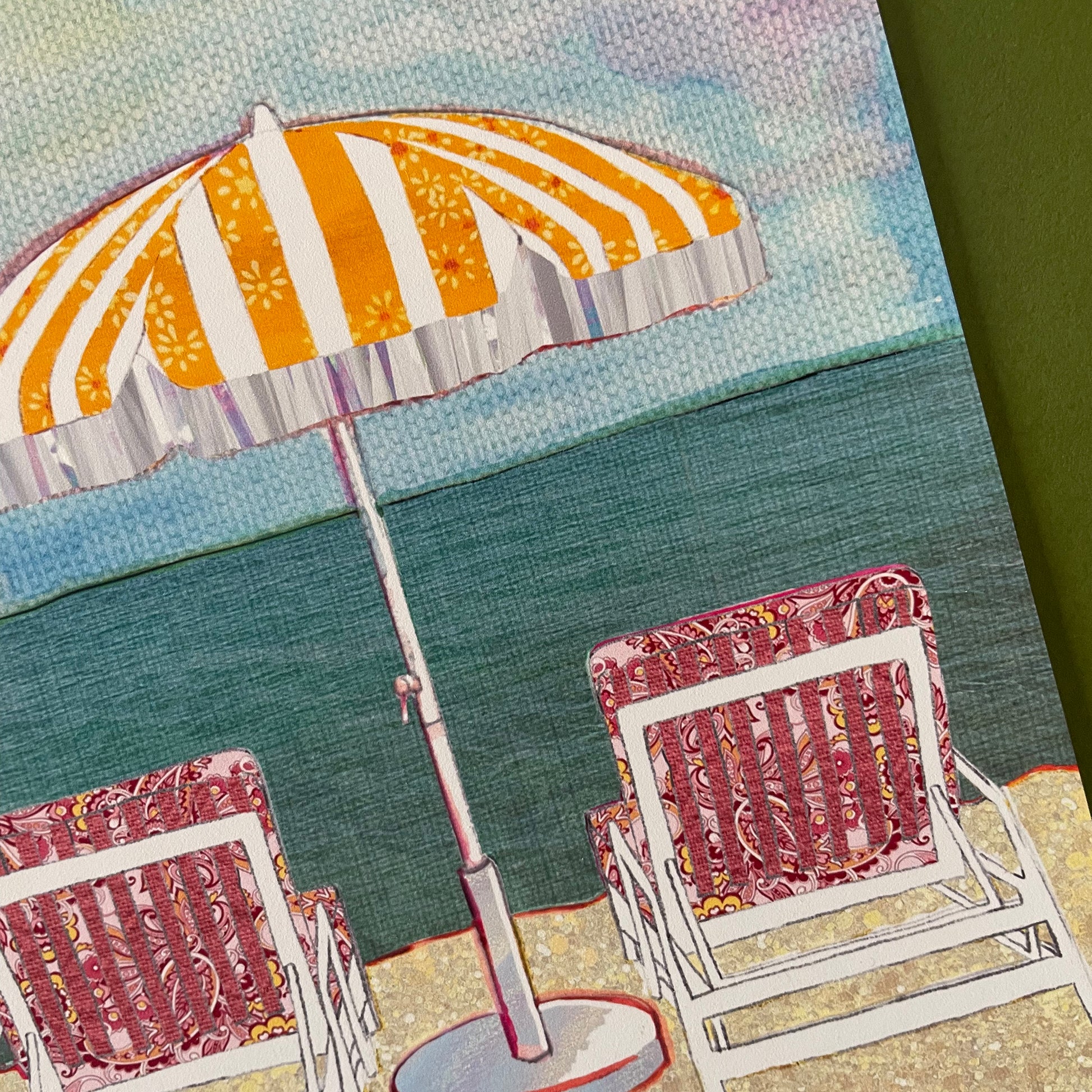 Close up image of the detail and texture of an illustrated beach scene featuring 2 chairs and a parasol by the sea