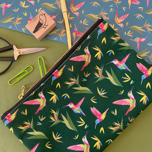 Image shows a forest green coloured zip pouch with a colourful hummingbird print on it.
