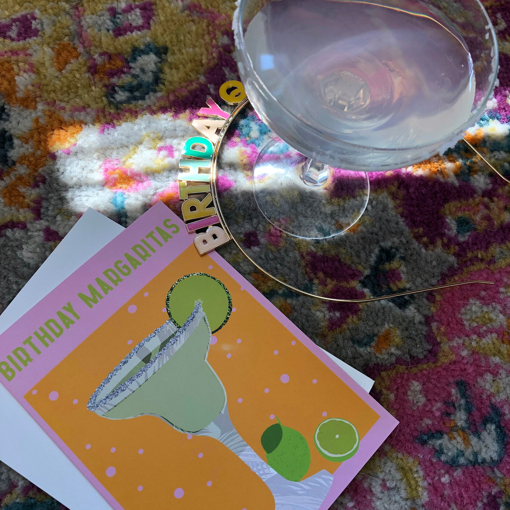 Image shows a yellow and pink coloured  birthday card with the greeting 'Birthday Margaritas' and a lime green cocktail with limes and a glitter salt rim.