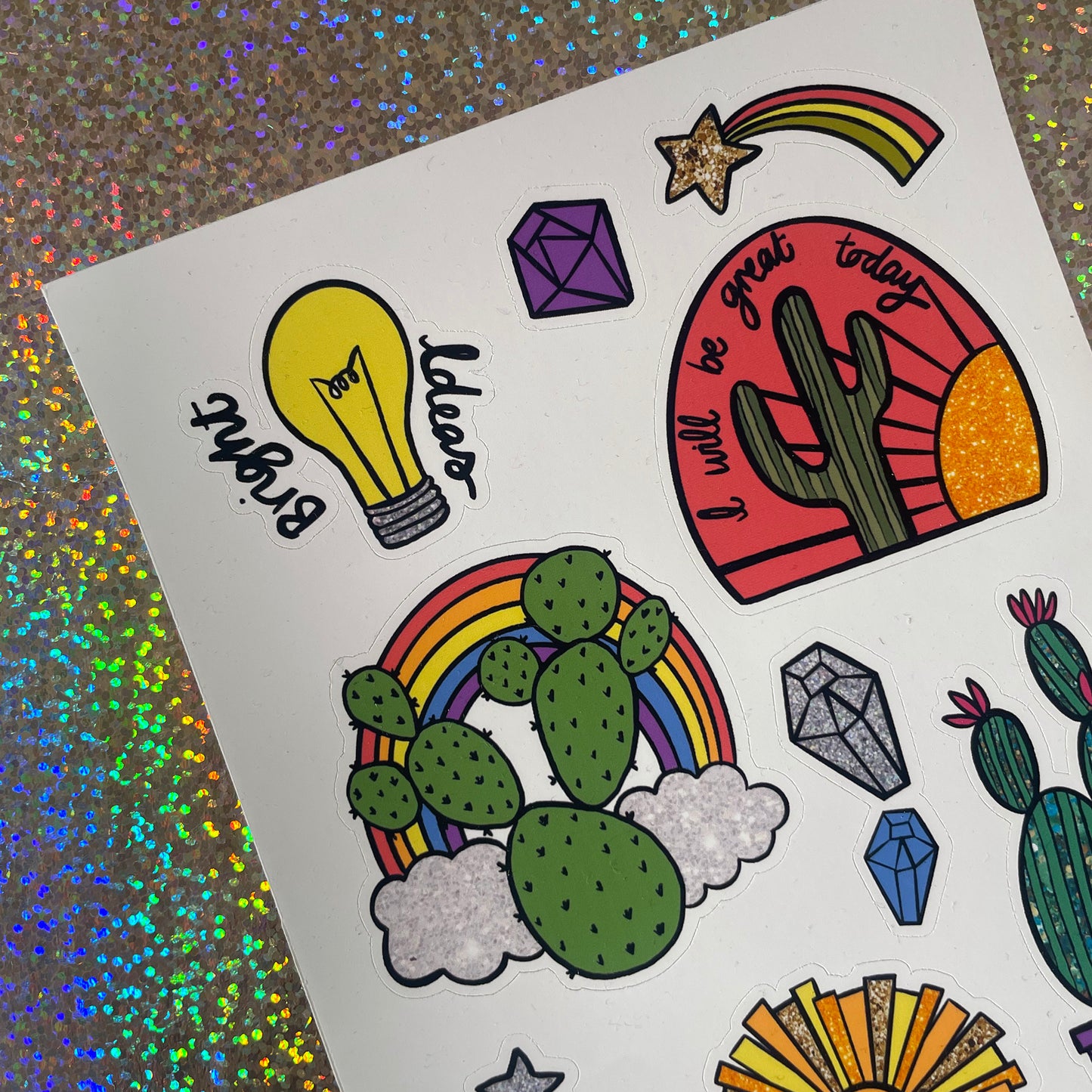 Image shows a bright  and colourful sticker sheet with illustrated designs of cacti, gems and other bright designs.