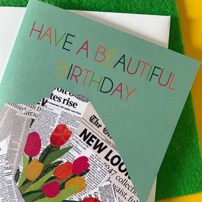Image of a pastel green card that reads Have a Beautiful Birthday and features a unique, collaged illustration of a bouquet of tulips in newspaper.