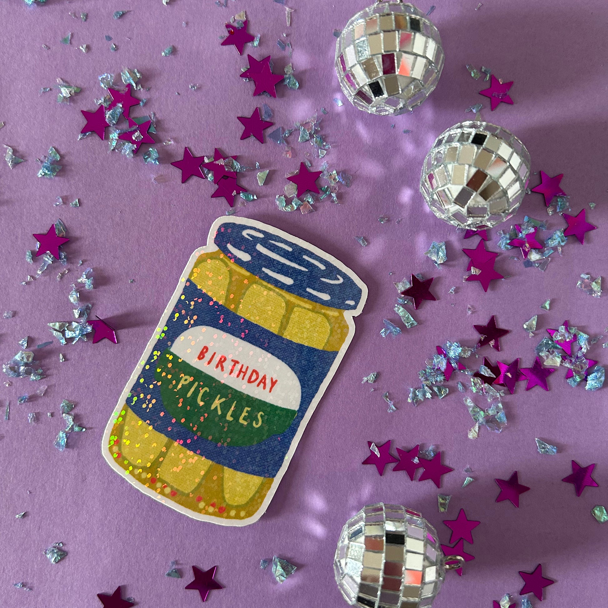 Sticker of a jar labeled 'Birthday Pickles' surrounded by disco balls and stars on a purple background