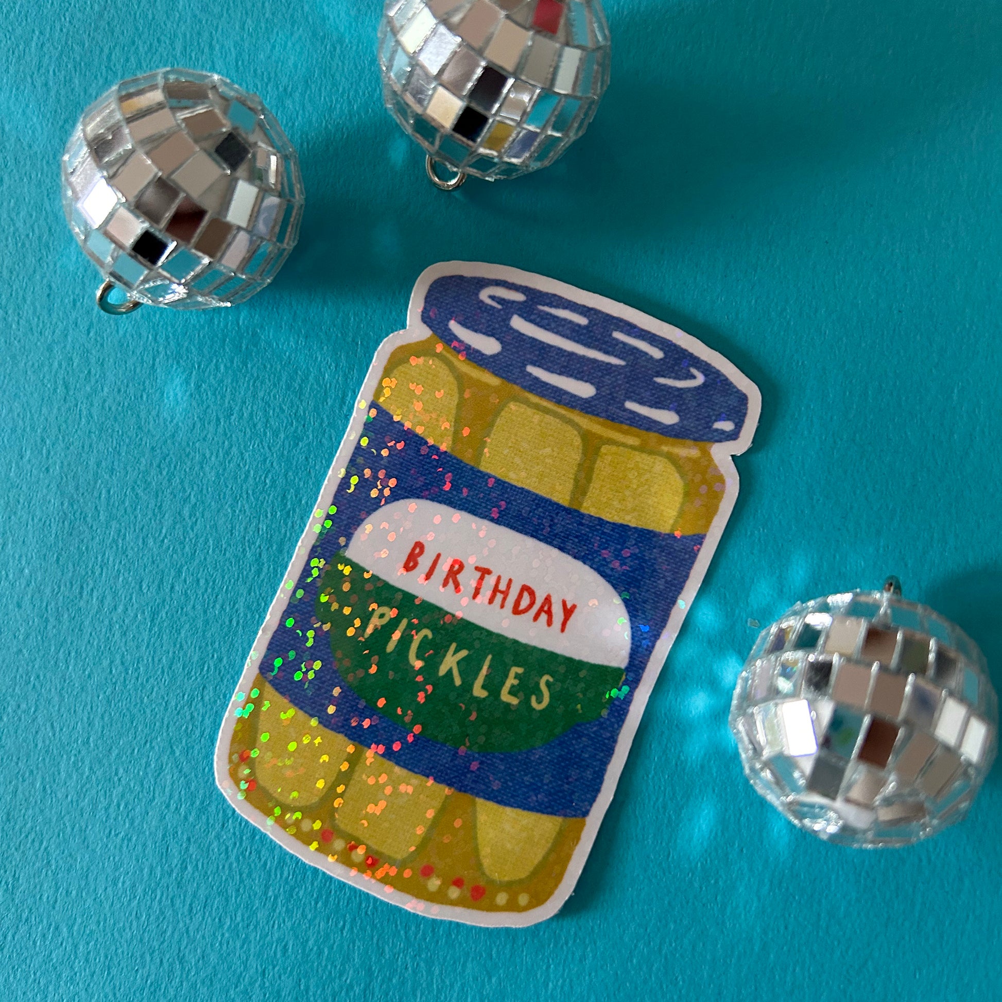 Sticker of a jar labeled 'Birthday Pickles' on a blue background with disco balls.