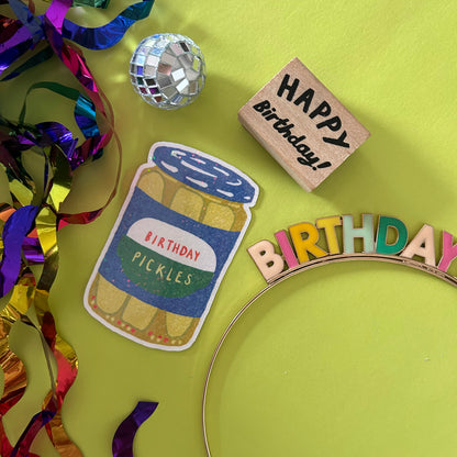 Birthday-themed items including a 'Happy Birthday' block, 'Birthday Pickles' sticker, and colorful letters on a green background.
