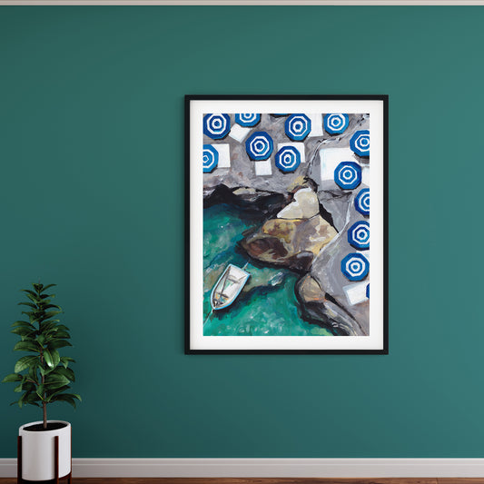 Image of a teal wall with a framed print of a painting of capri featuring striped umbrellas and aqua water with rocks and a small boat.
