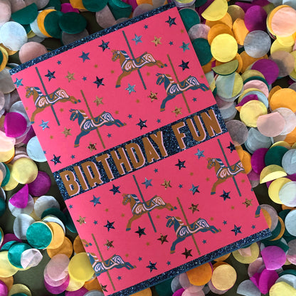 Bright and fun birthday card featuring a carousel horse design on a background of confetti