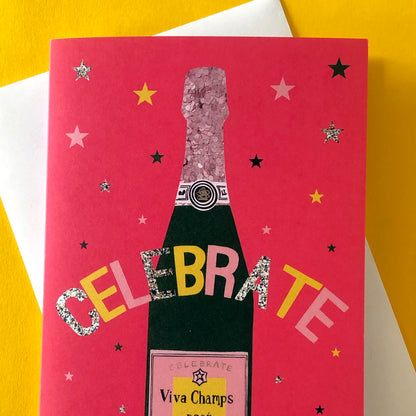 Image shows a bright red celebration card featuring a champagne bottle and stars